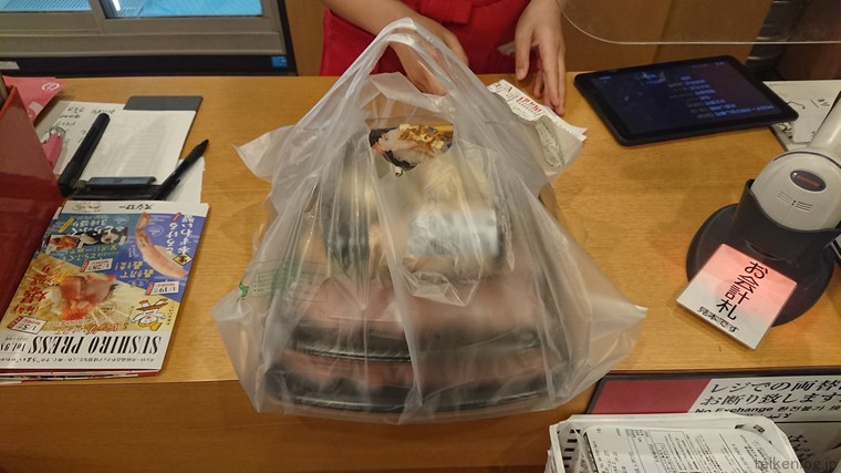 スシロー店内のカウンターで注文した寿司を受け取る