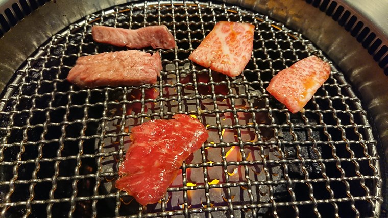 肉の万世の3種盛りランチの牛タン(左上)、カルビ(右上)、赤身(下)を焼いている様子