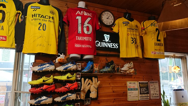 ステーキハウスMOMO 柏店の店内の壁に掛かっているサッカーのユニフォームやシューズ