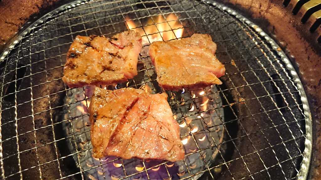 焼肉宝島のプレミアムコースでしか注文できない「国産牛カルビ(たれ)」を焼いているようす