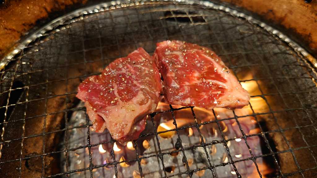 焼肉宝島の宝島スペシャルコース以上から注文できる「希少厚切りサガリ」を焼いているようす