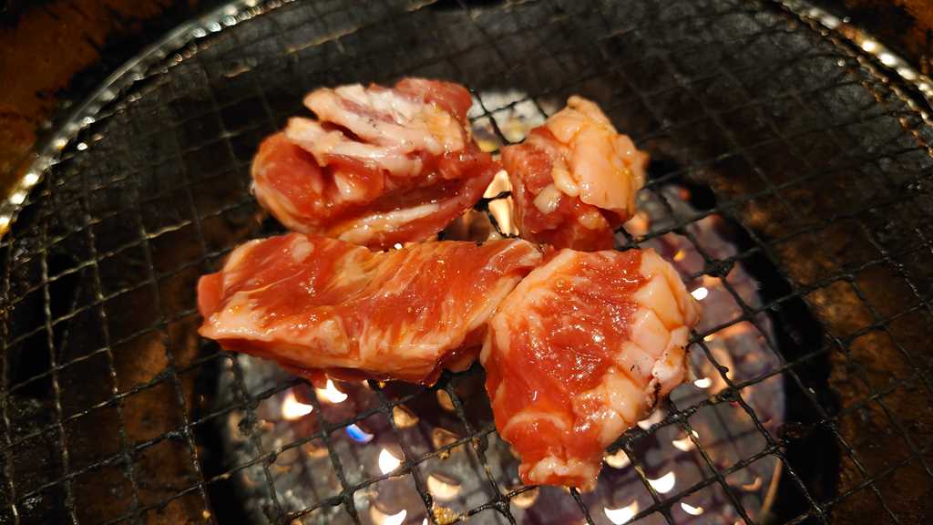 焼肉宝島の宝島スペシャルコース以上から注文できる「中落ちカルビ(たれ)」を焼いているようす その1
