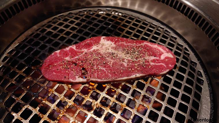 牛角の食べ放題だと牛角90品コース以上から注文できる「熟成上ロースステーキ」を焼いているようす