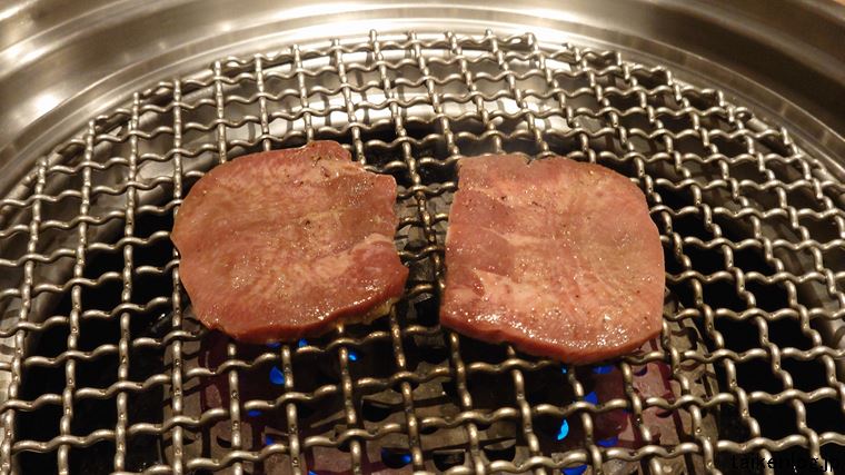 くいどんの132品 国産牛特上コース利用時に最初に提供される肉盛合わせの「上タン塩」を焼いているようす