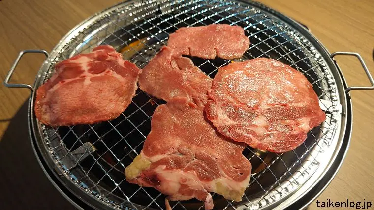 焼肉五苑 名護店のプレミアム寿コース利用時に注文できる「上牛タン」を焼いているようす