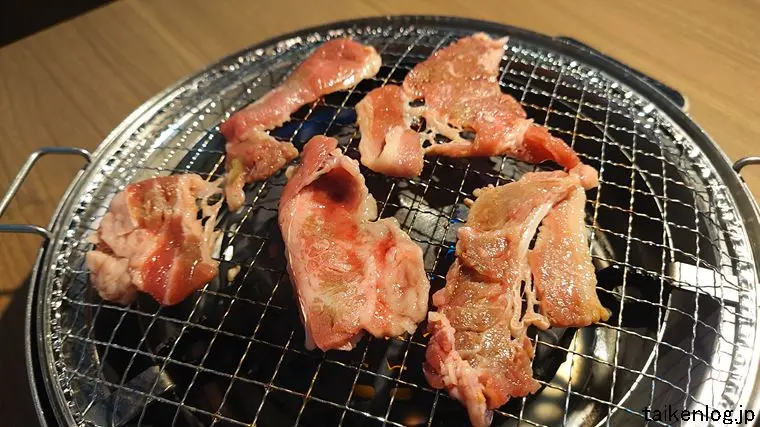 焼肉五苑 名護店の食べ放題 結コース以上利用時に注文できる「ジューシーカルビ」を焼いているようす